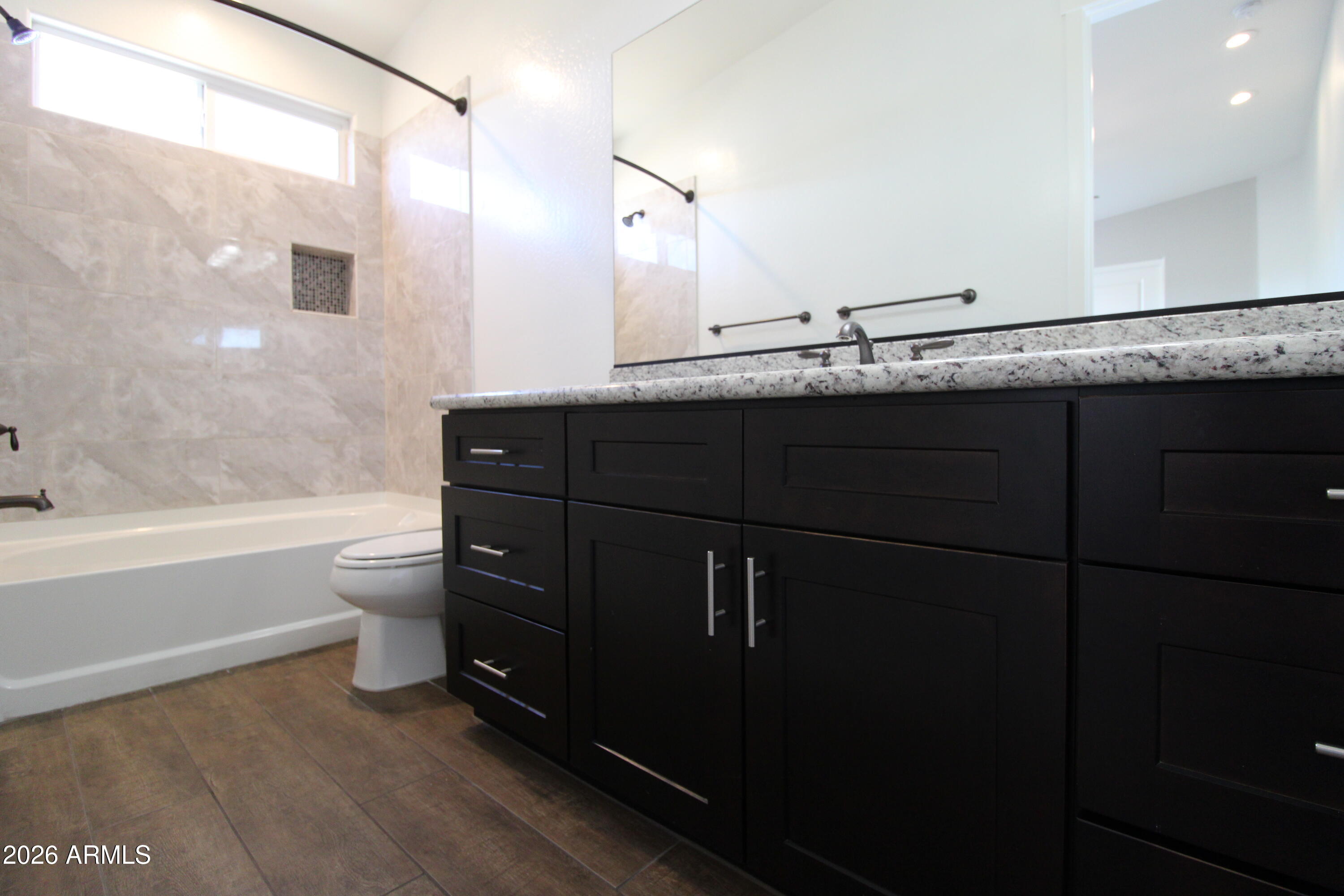 1024 East Curry Road, Unit 1A Tempe, AZ 85288 - Photo 17 of 23 a bathroom with a granite countertop sink a toilet and bathtub