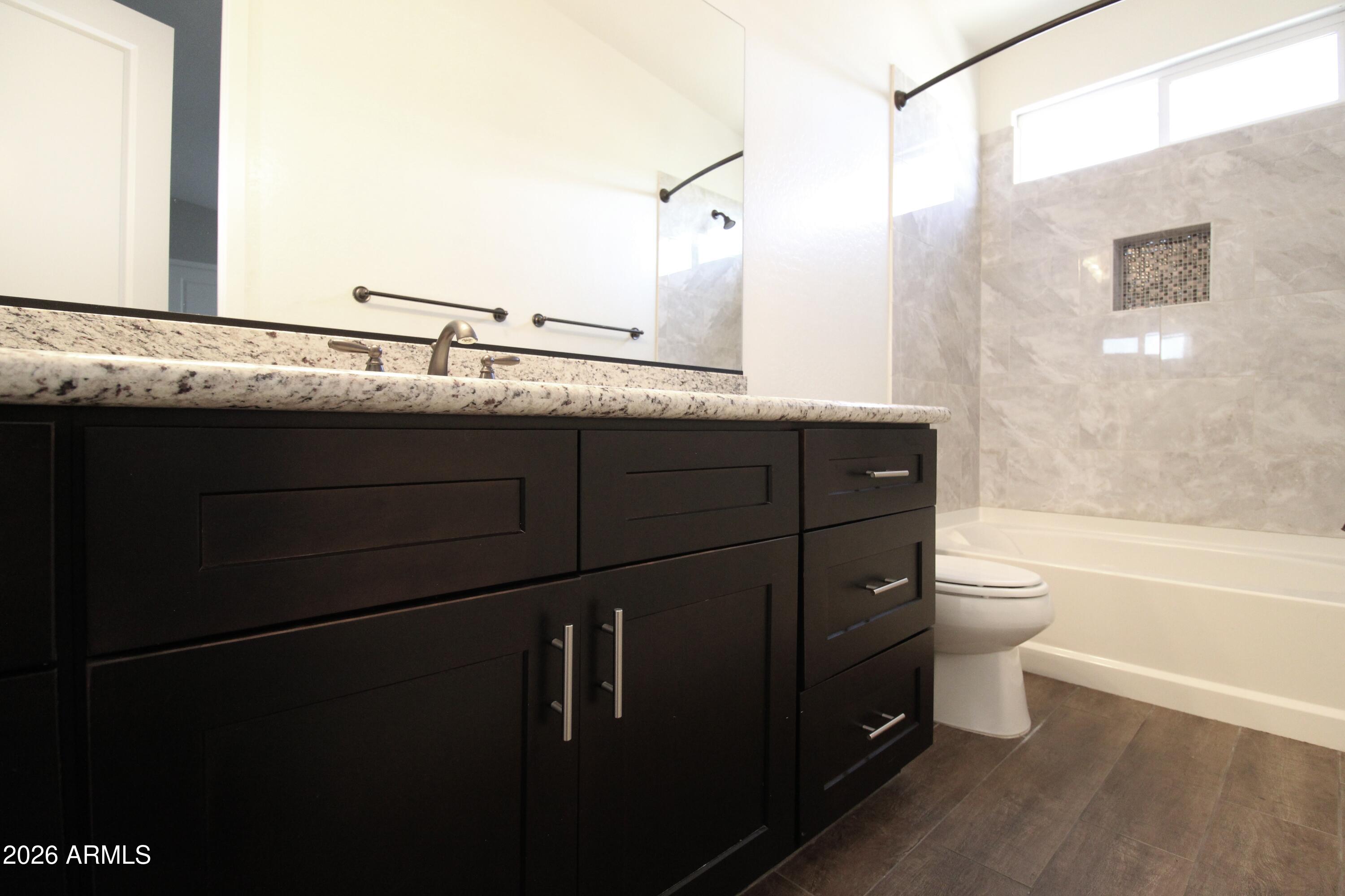 1024 East Curry Road, Unit 1A Tempe, AZ 85288 - Photo 18 of 23 a bathroom with a granite countertop sink toilet and shower