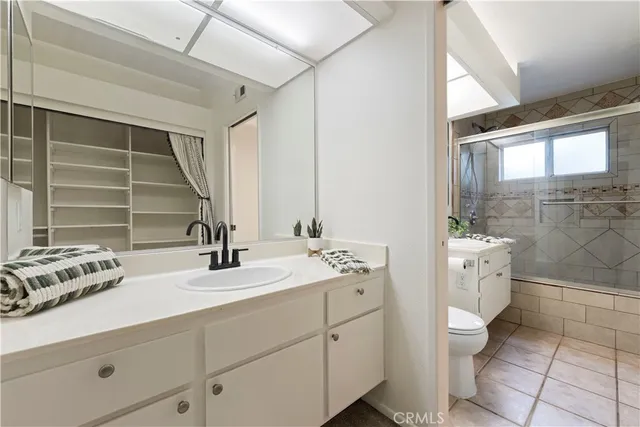 a bathroom with a double vanity sink a toilet and a mirror