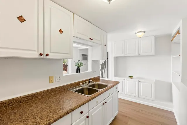 a kitchen with granite countertop a sink and cabinets