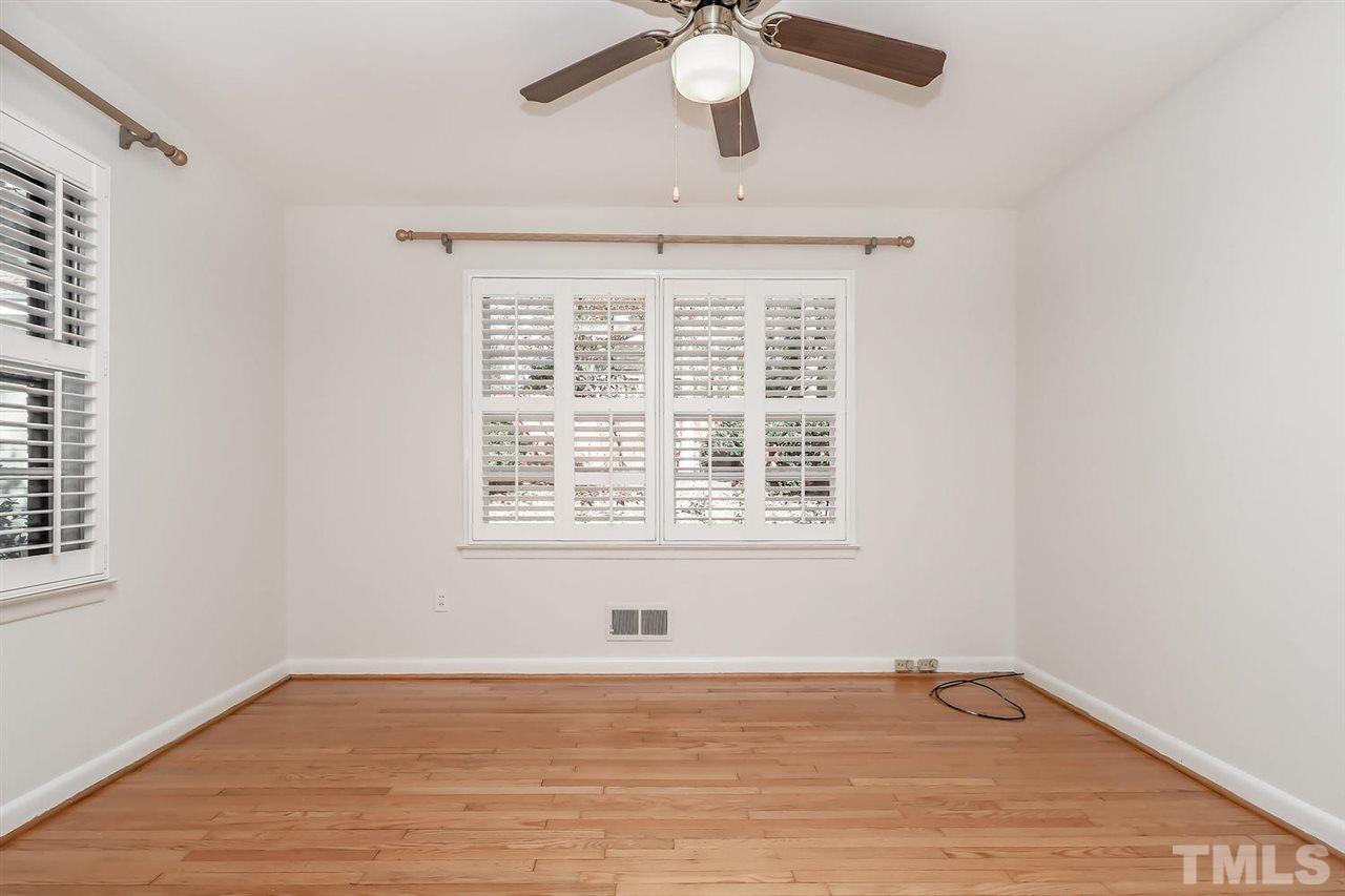 5800 Contour Drive Raleigh, NC 27612 - Photo 14 of 19 an empty room with wooden floor chandelier fan and windows