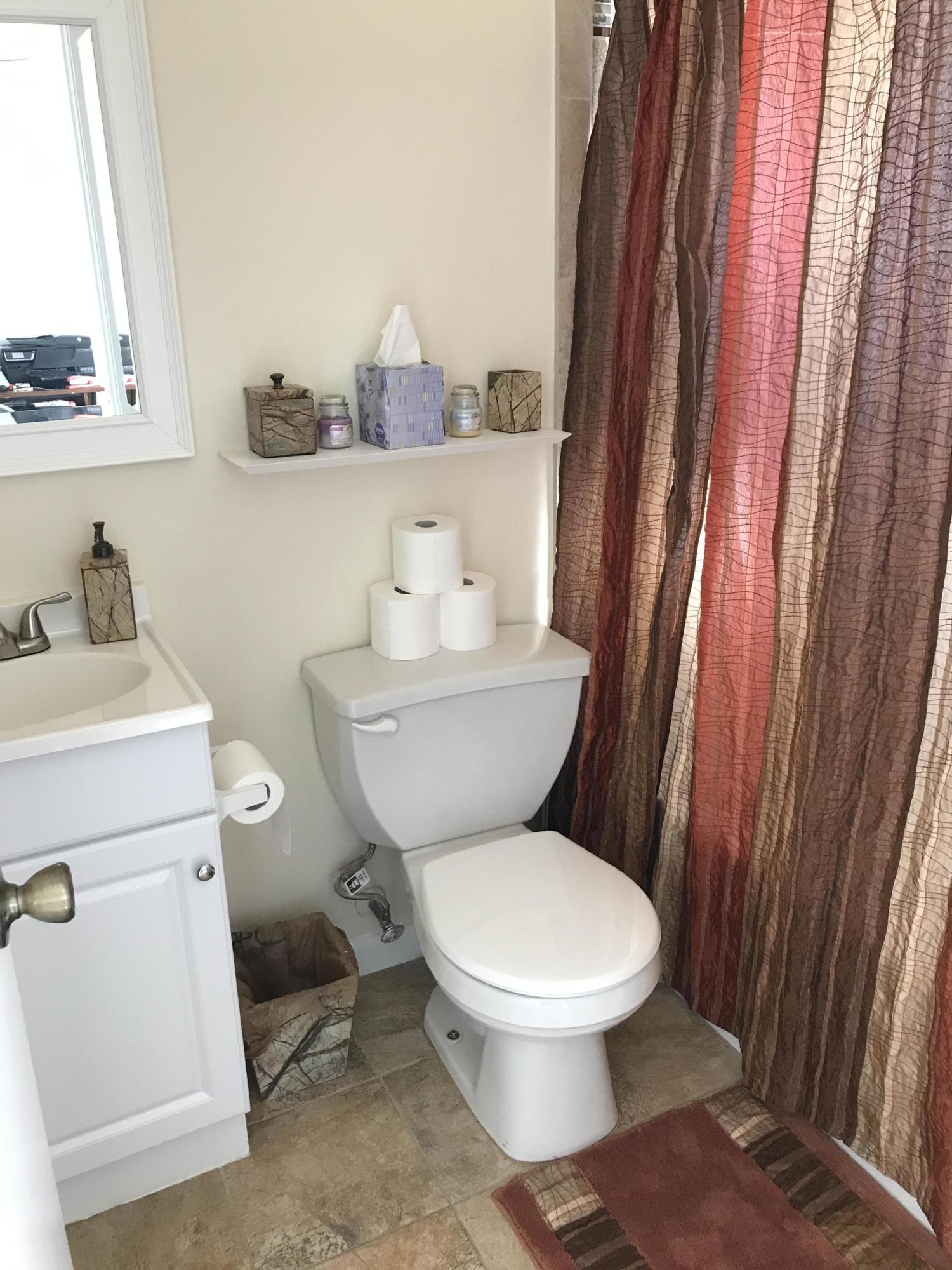 164 Riviera Circle Weston, FL 33326 - Photo 18 of 26 a white toilet sitting next to a bathroom sink