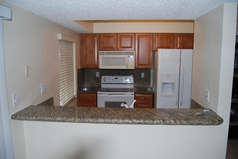 164 Riviera Circle Weston, FL 33326 - Photo 2 of 26 a kitchen with granite countertop a refrigerator and cabinets