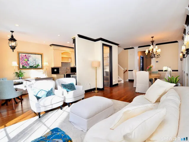 a living room with stainless steel appliances furniture and a kitchen view