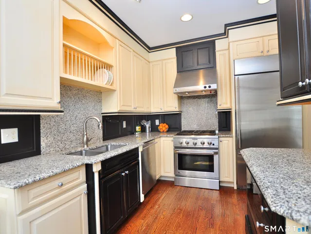 a kitchen with stainless steel appliances granite countertop a stove and a sink