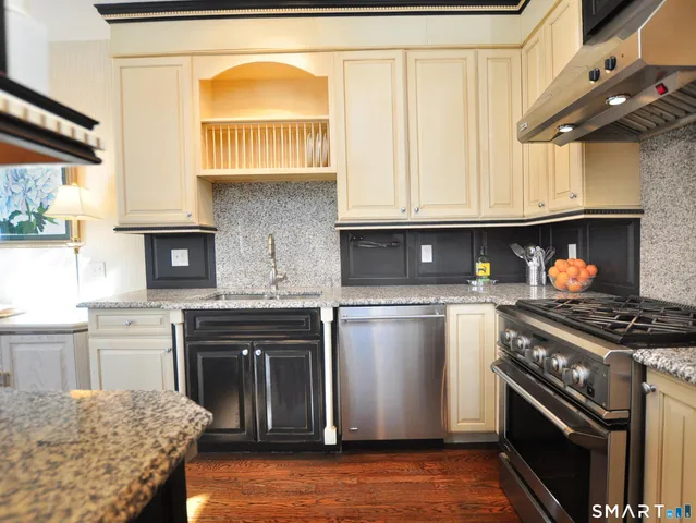 a kitchen with granite countertop stainless steel appliances and wooden cabinets