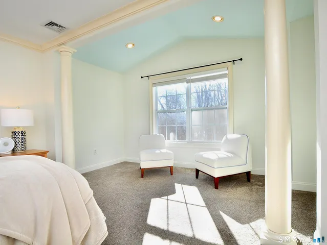 a bedroom with a bed and a large mirror