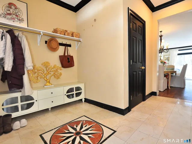 a dining room with wooden floor a chandelier a wooden table and chairs