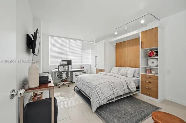 a bedroom with a bed and a television
