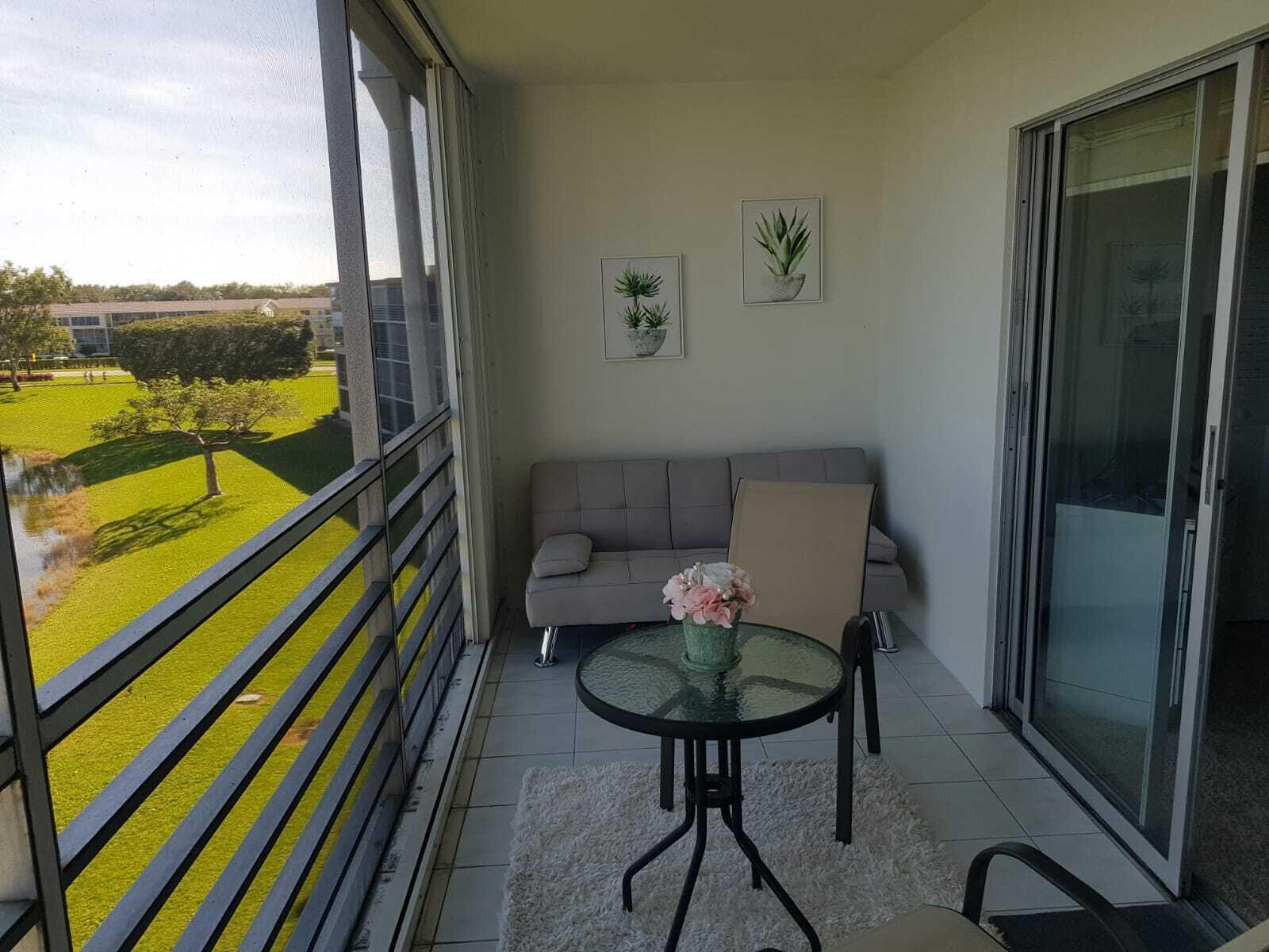 4014 Cornwall East, Unit 4014 Boca Raton, FL 33434 - Photo 59 of 67 a balcony with view of couch and wooden floor