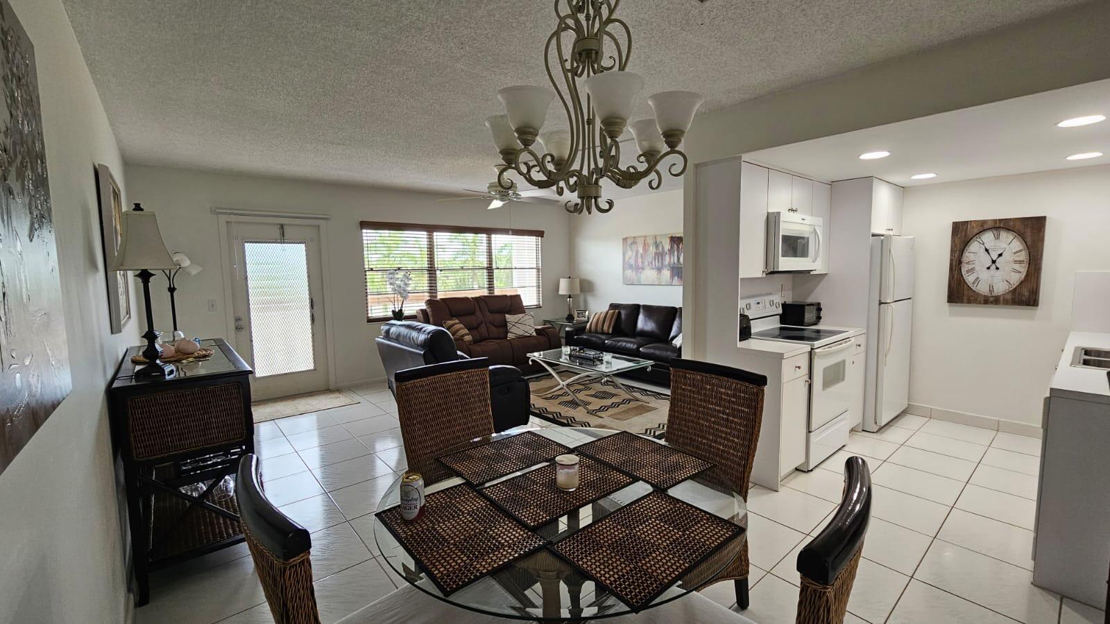 4014 Cornwall East, Unit 4014 Boca Raton, FL 33434 - Photo 7 of 67 a living room with furniture a chandelier and a dining table