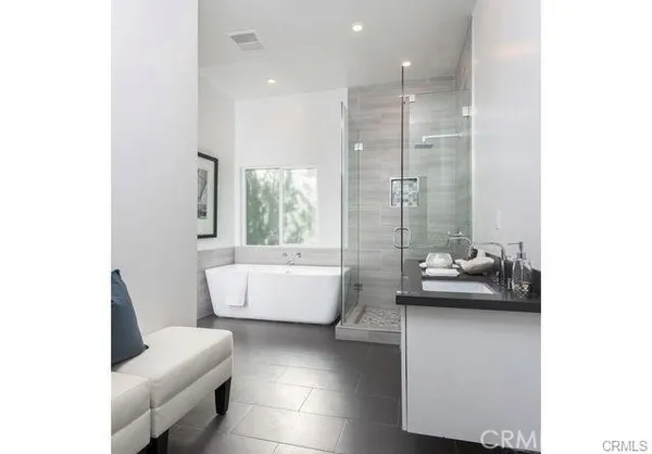 a bathroom with a tub sink and glass door