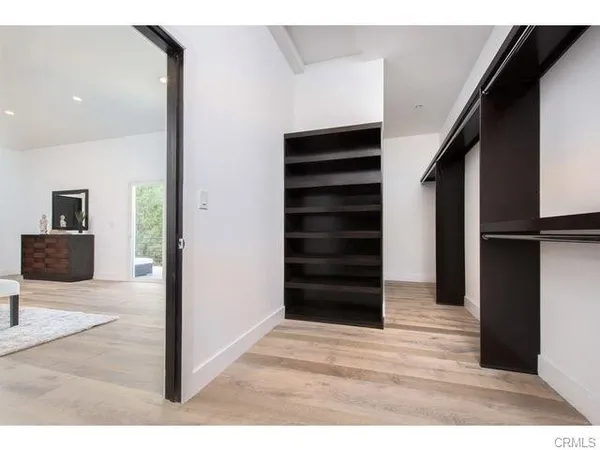 a view of a bedroom with wooden floor and stairs