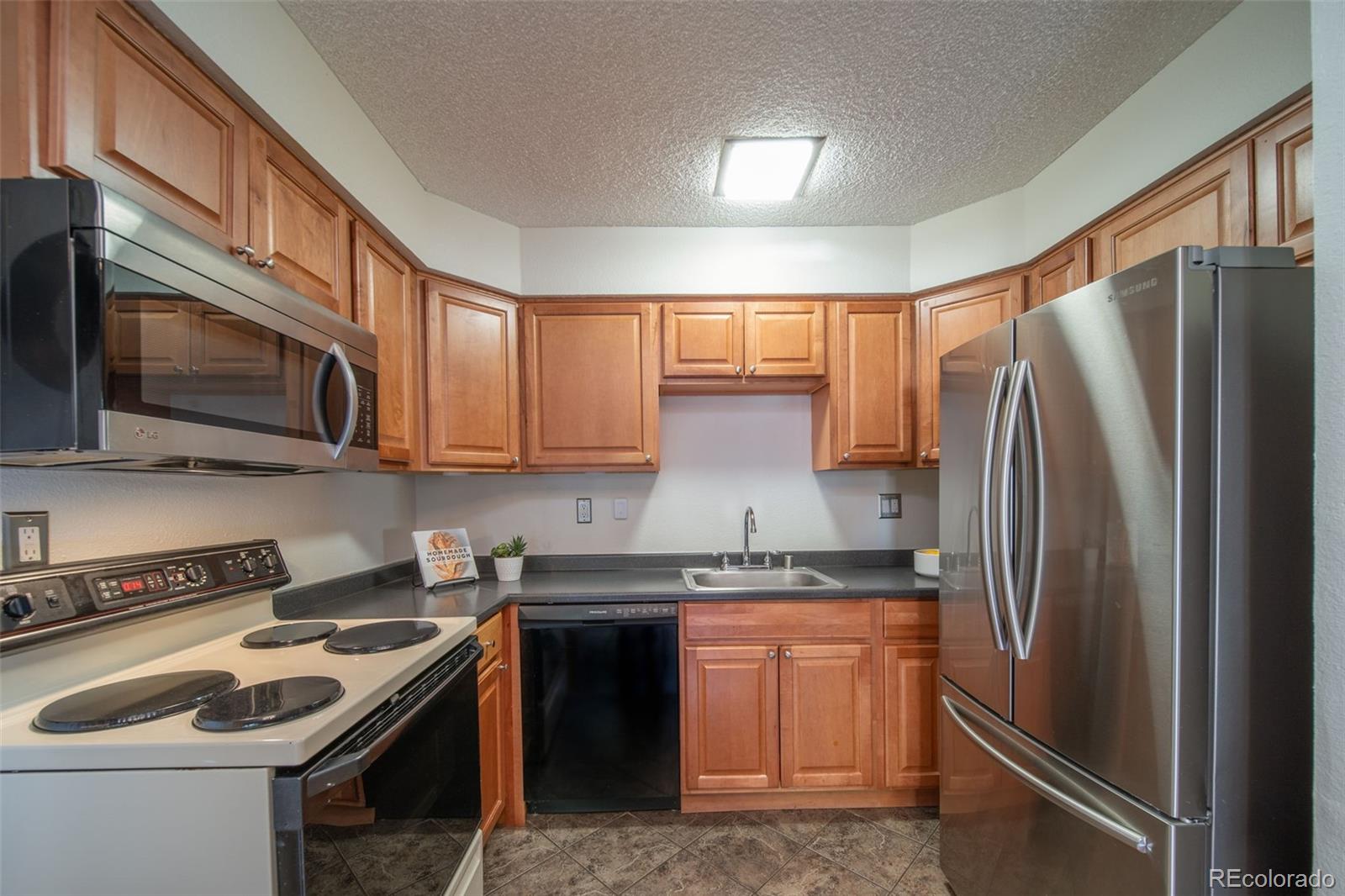 3375 Chisholm Trail, Unit A102 Boulder, CO 80301 - Photo 12 of 40 a kitchen with stainless steel appliances granite countertop a refrigerator stove top oven and sink