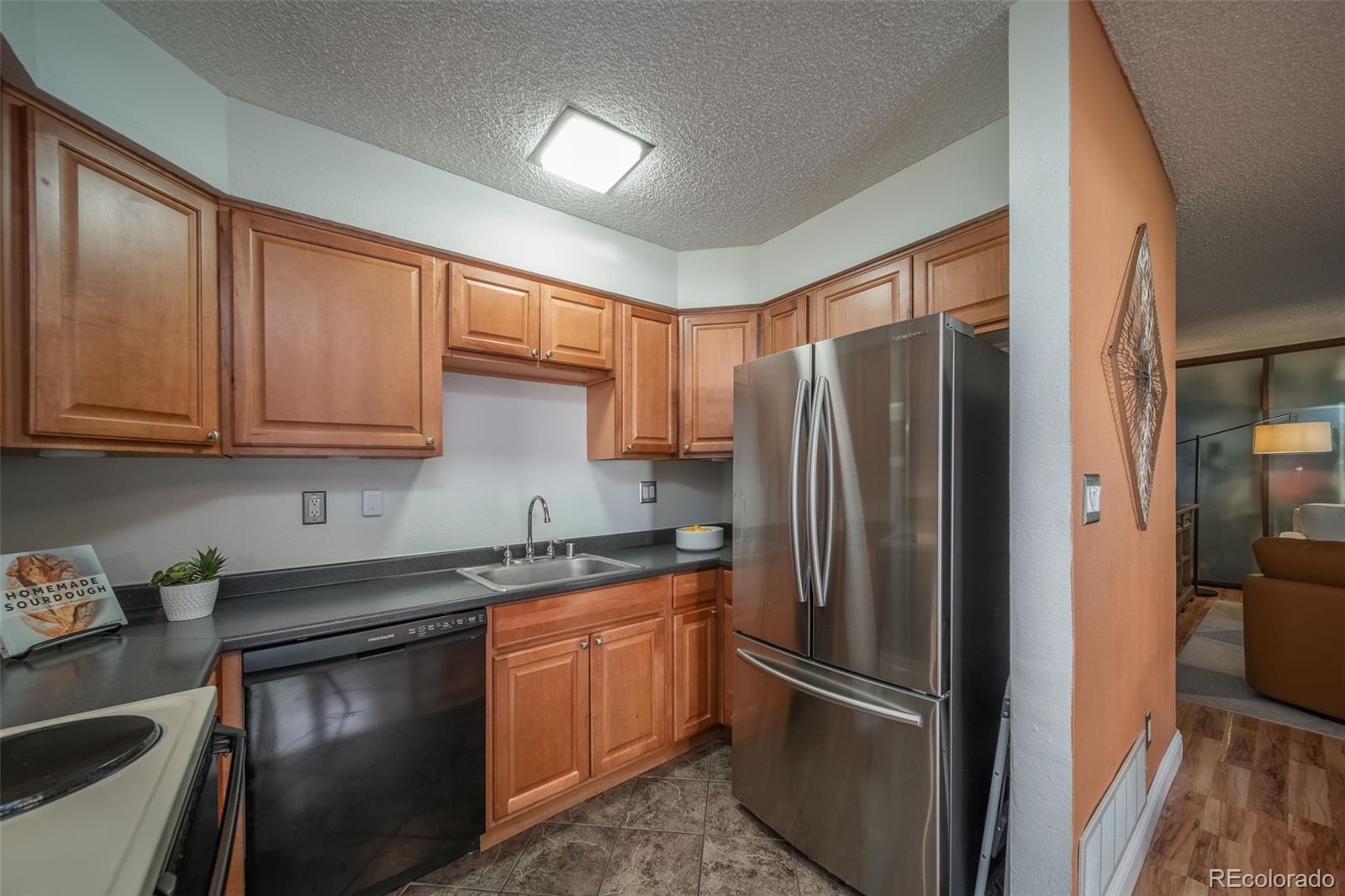 3375 Chisholm Trail, Unit A102 Boulder, CO 80301 - Photo 13 of 40 a kitchen with stainless steel appliances granite countertop a refrigerator a sink and white cabinets
