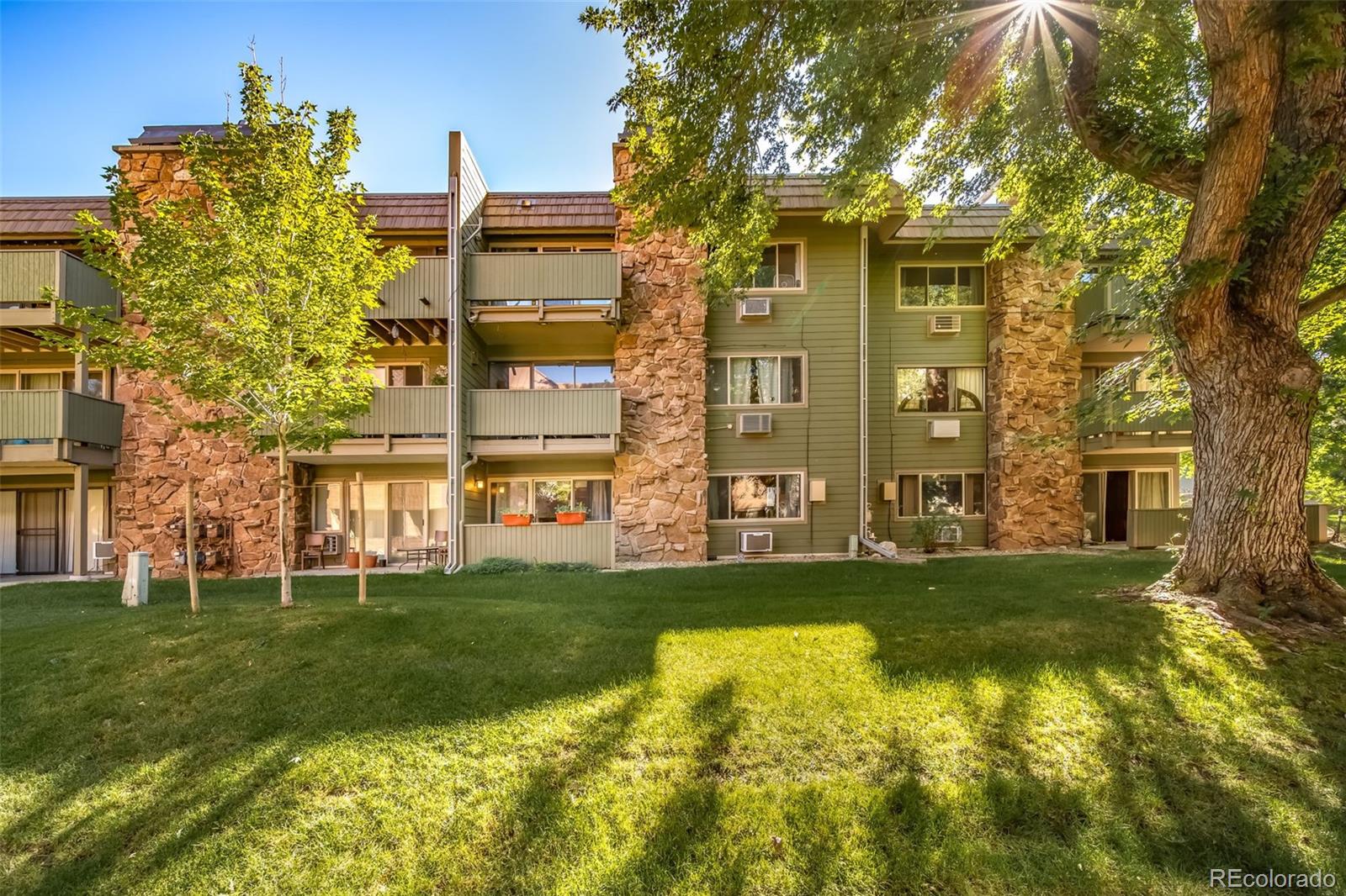 3375 Chisholm Trail, Unit A102 Boulder, CO 80301 - Photo 22 of 40 a view of a large building with a big yard and large trees