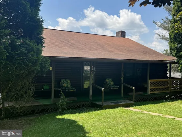 a backyard of a house with plants and large tree