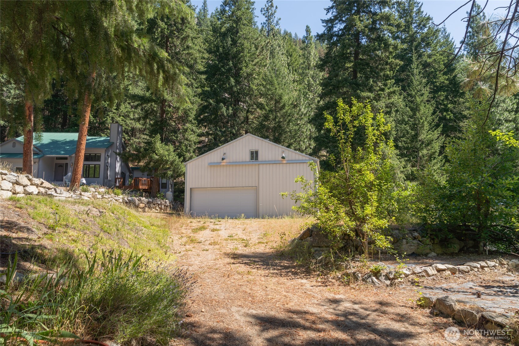 17976 Entiat River Road Entiat, WA 98822 - Photo 5 of 40 a backyard of a house with large trees and plants