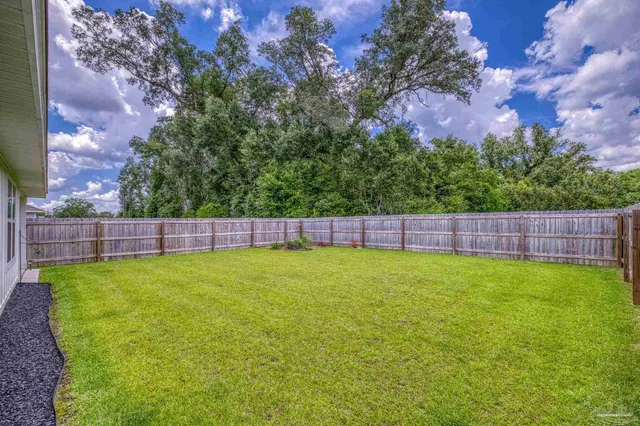 a view of a house with potted plants and a bench