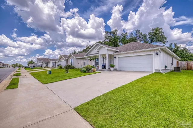 a front view of house with a yard and a large tree