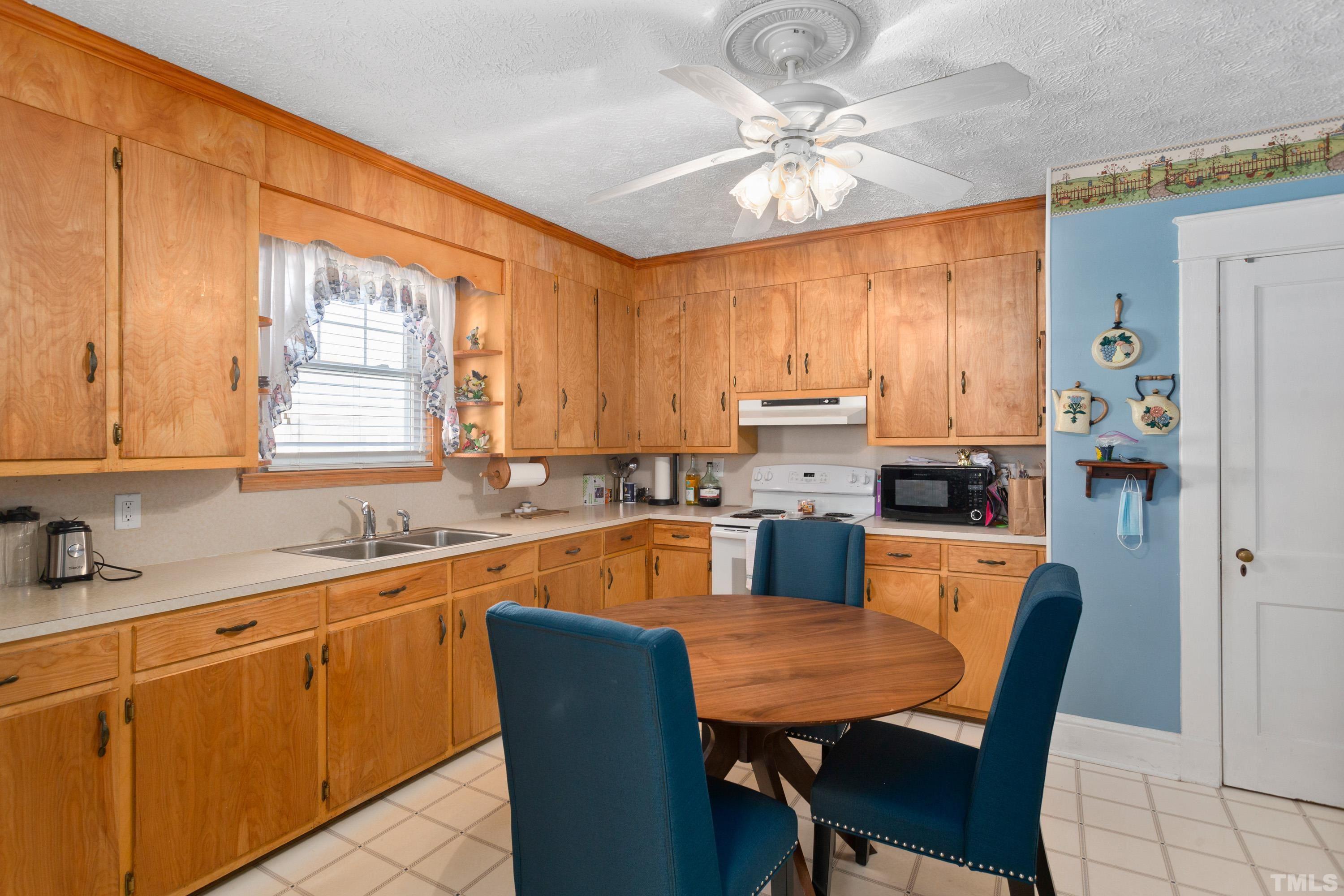 213 Edgar Street Roxboro, NC 27573 - Photo 20 of 29 a kitchen with stainless steel appliances granite countertop a sink dishwasher a stove a refrigerator with a dining table and chairs