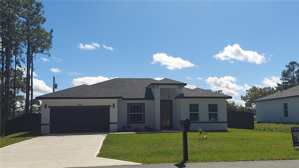 a front view of a house with a yard and garage