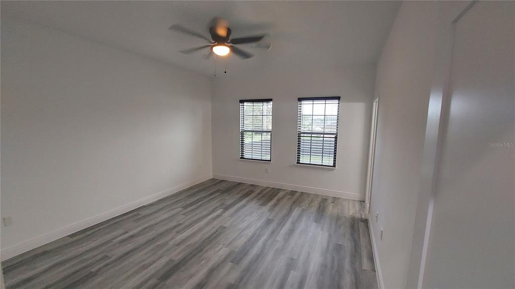 5984 Southwest 128th Street Road Ocala, FL 34473 - Photo 12 of 23 wooden floor in an empty room with a window