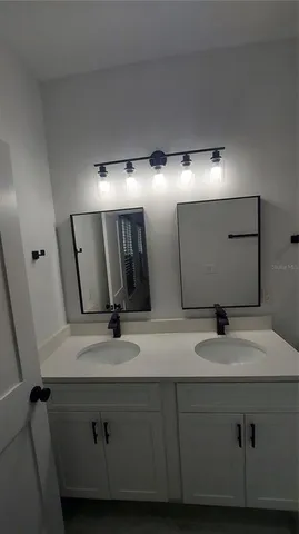 a bathroom with a double vanity sink and a mirror