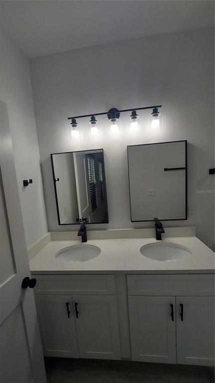 5984 Southwest 128th Street Road Ocala, FL 34473 - Photo 16 of 23 a bathroom with a double vanity sink and a mirror