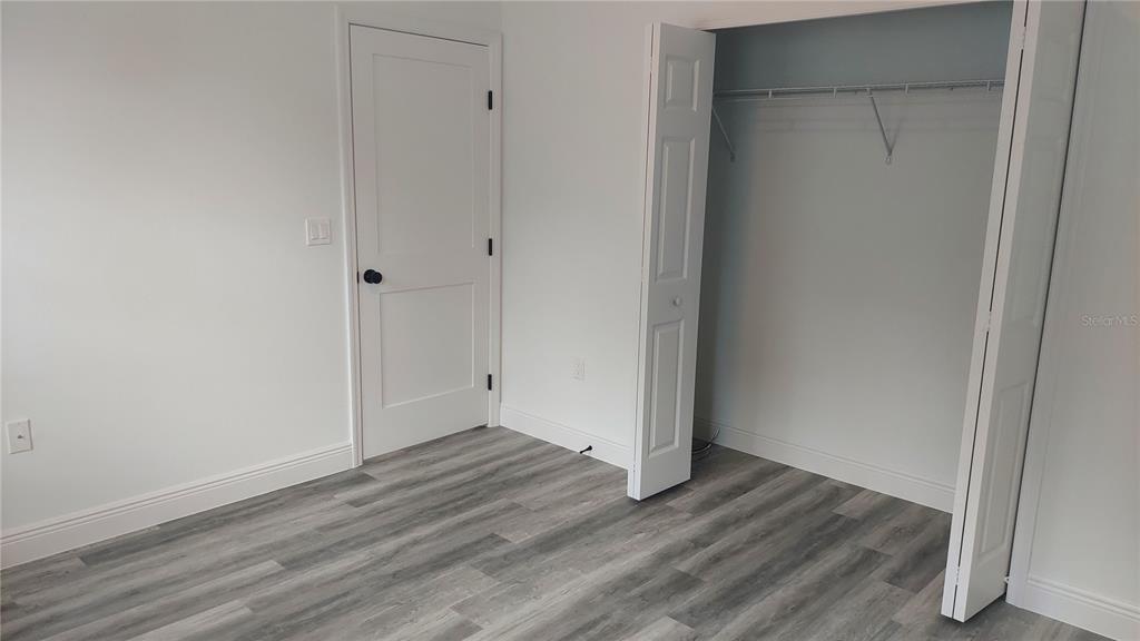 5984 Southwest 128th Street Road Ocala, FL 34473 - Photo 17 of 23 a view of an empty room with wooden floor