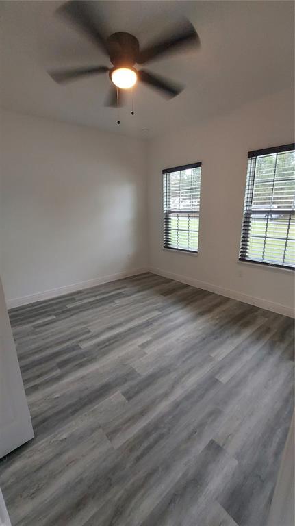 5984 Southwest 128th Street Road Ocala, FL 34473 - Photo 18 of 23 an empty room with wooden floor and windows