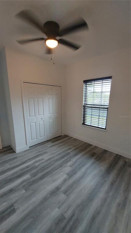 5984 Southwest 128th Street Road Ocala, FL 34473 - Photo 22 of 23 an empty room with wooden floor fan and windows
