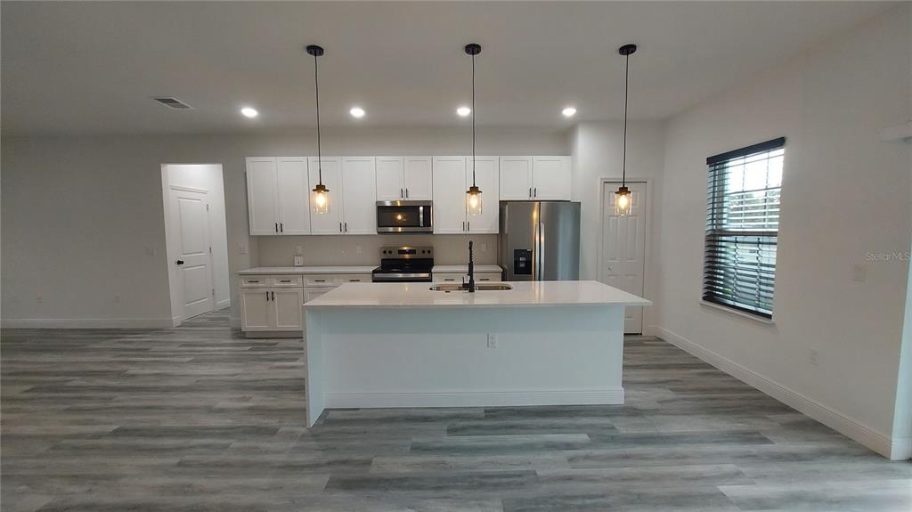 5984 Southwest 128th Street Road Ocala, FL 34473 - Photo 8 of 23 a view of kitchen with stainless steel appliances granite countertop a stove a sink a refrigerator and a oven with wooden floor