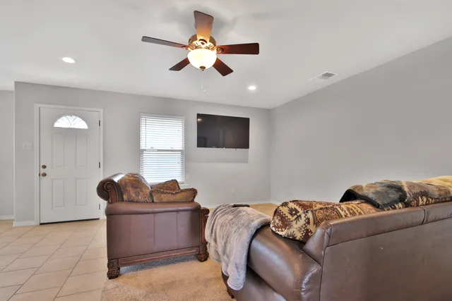 a living room with furniture and a ceiling fan