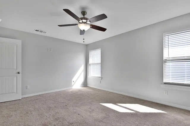 a view of a big room with windows and chandelier fan