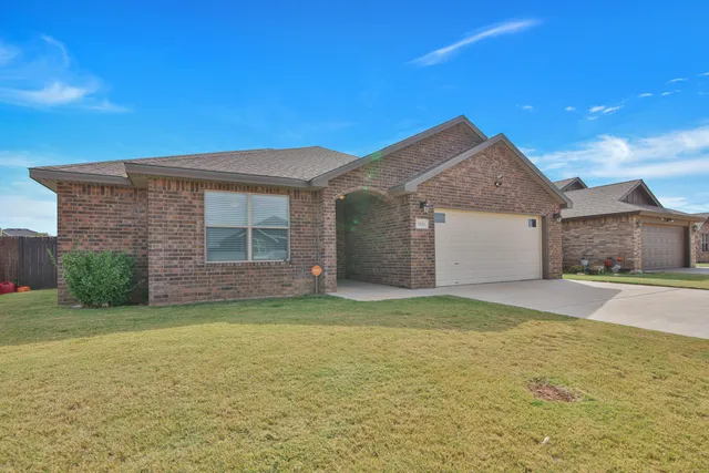 a view of a house with a yard and garage