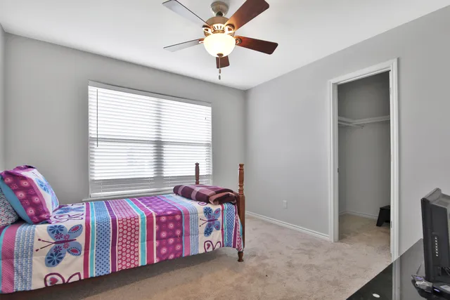 a spacious bedroom with a bed and a chandelier