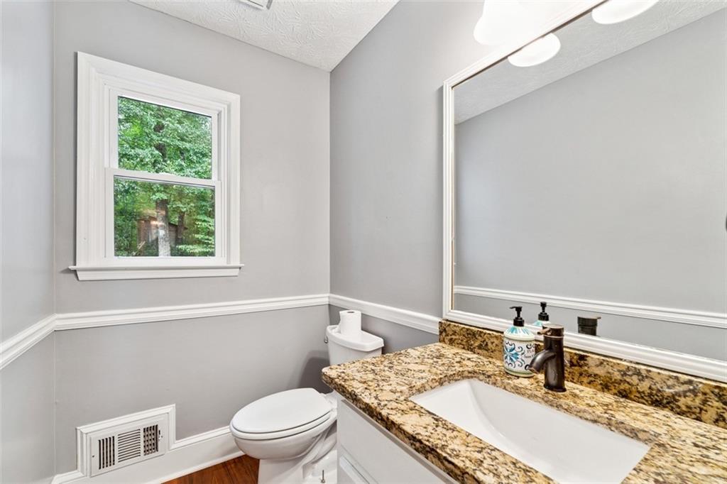 2017 Parsons Ridge Duluth, GA 30097 - Photo 16 of 53 a bathroom with a granite countertop sink a mirror and a toilet