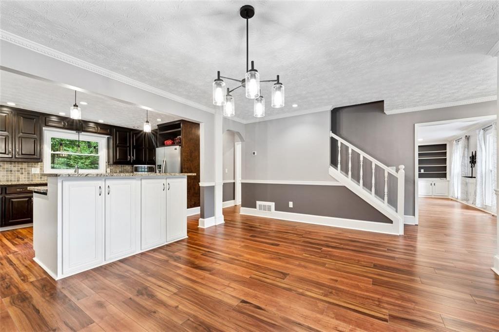 2017 Parsons Ridge Duluth, GA 30097 - Photo 10 of 53 a view of a kitchen with kitchen island a sink wooden floor and a large window