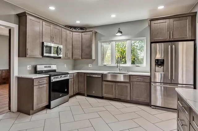 a kitchen with stainless steel appliances granite countertop a stove a refrigerator and a microwave