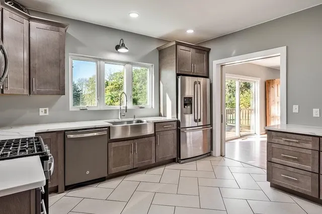 an empty room with wooden floor fireplace and windows