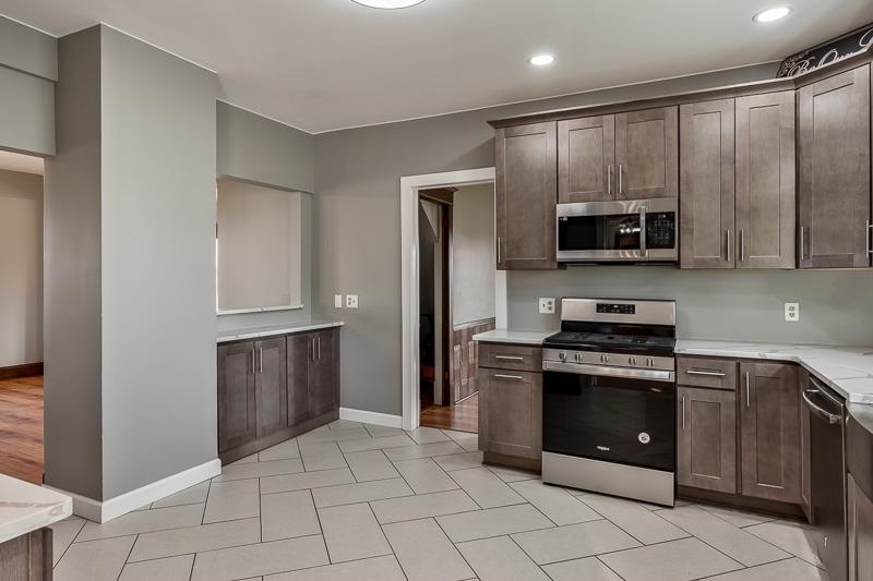 15685 West State Road Pecatonica, IL 61063 - Photo 16 of 69 a kitchen with stainless steel appliances granite countertop a stove a refrigerator and a microwave