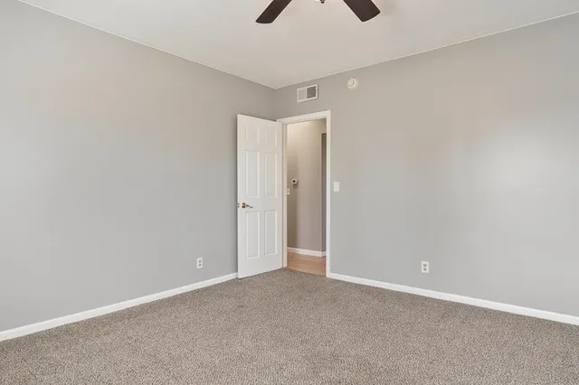 an empty room with chandelier fan