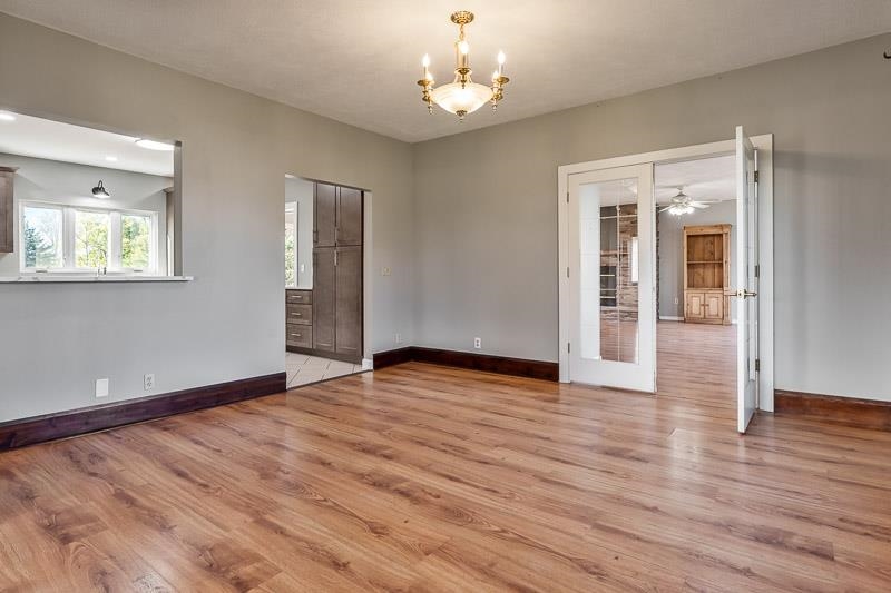 15685 West State Road Pecatonica, IL 61063 - Photo 9 of 69 an empty room with wooden floor chandelier and windows