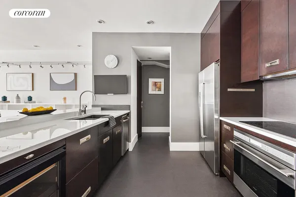 a living room with stainless steel appliances furniture a dining table and kitchen view