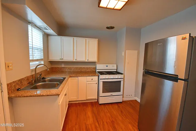 a kitchen with granite countertop a refrigerator stove and sink