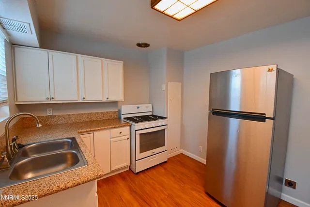 a kitchen with a refrigerator sink and cabinets