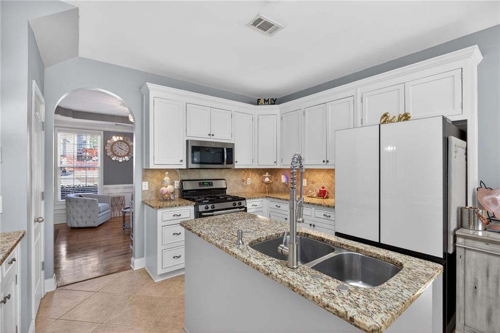 4817 Pepper Tree Lane Douglasville, GA 30135 - Photo 15 of 65 a kitchen with stainless steel appliances granite countertop a sink a stove and a refrigerator