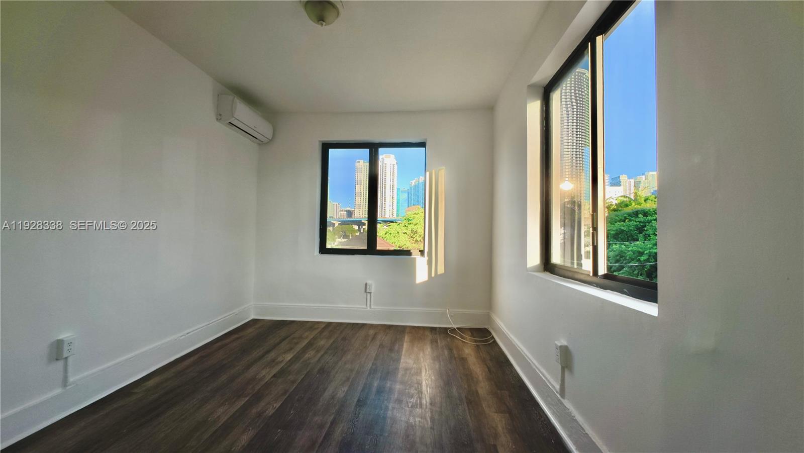 337 Southwest 5th Avenue, Unit 12 Miami, FL 33130 - Photo 12 of 21 an empty room with wooden floor and windows