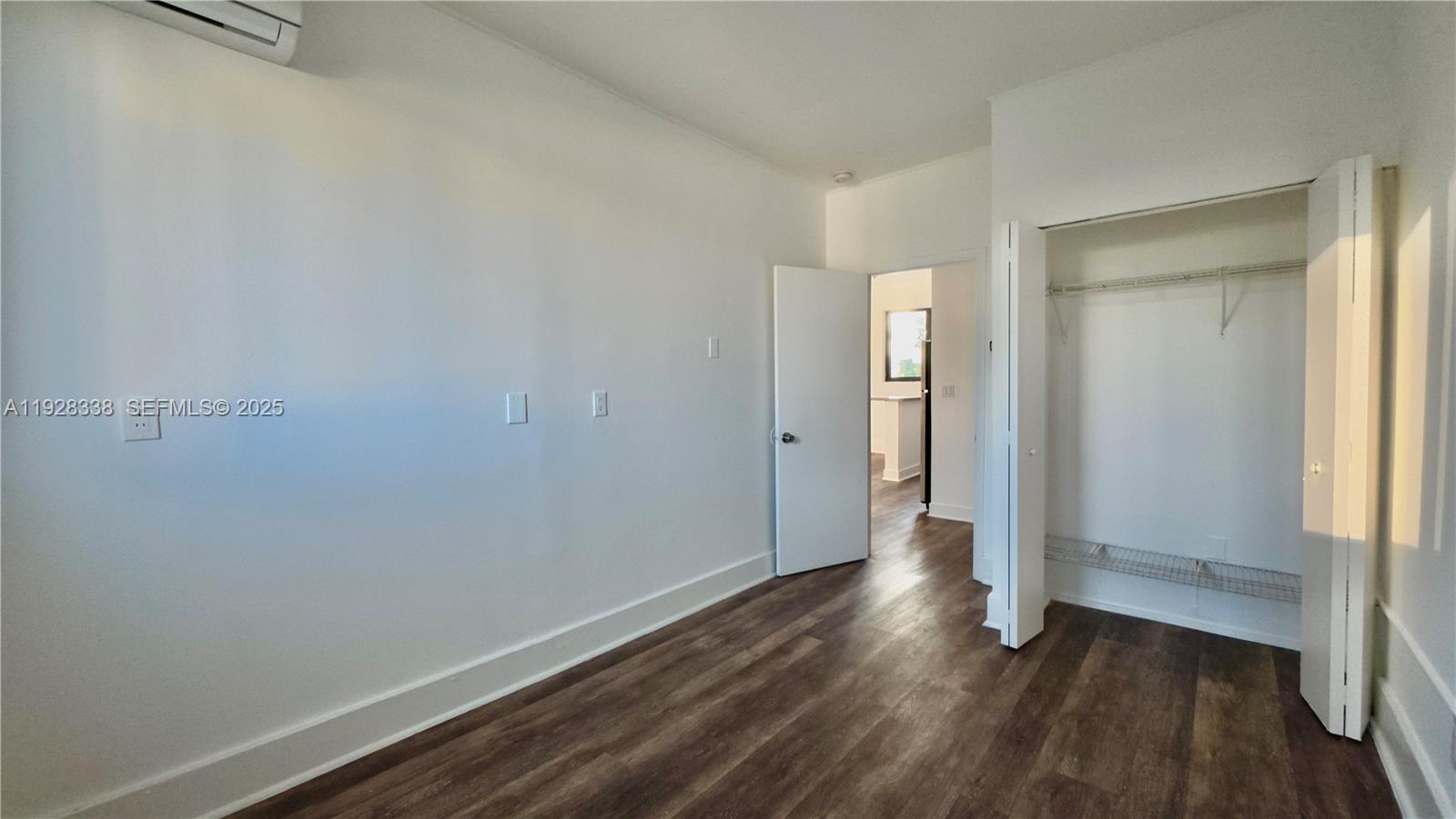 337 Southwest 5th Avenue, Unit 12 Miami, FL 33130 - Photo 15 of 21 a view of an empty room with wooden floor and a window